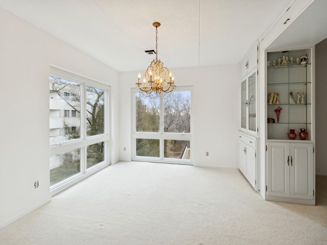 unfurnished dining area featuring a notable chandelier and light carpet