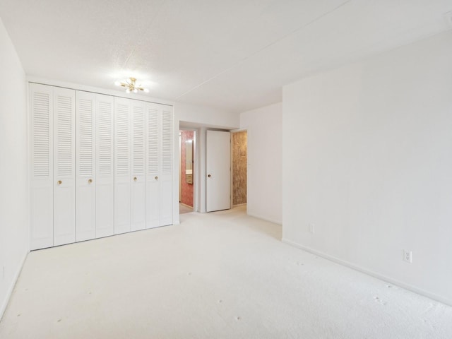 unfurnished bedroom with light colored carpet and a closet