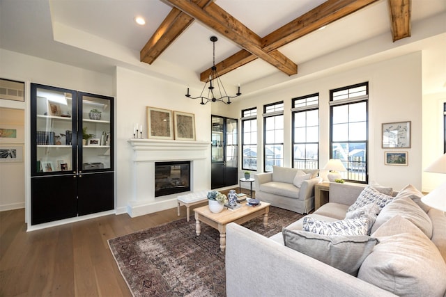 living room featuring beamed ceiling, a notable chandelier, and dark wood-type flooring