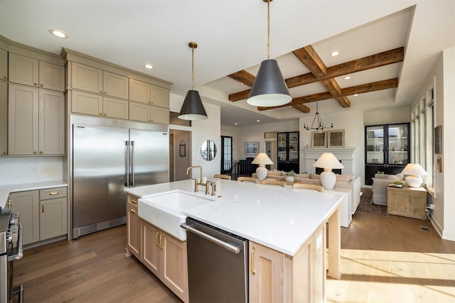 kitchen featuring a kitchen island with sink, hardwood / wood-style floors, stainless steel appliances, and sink