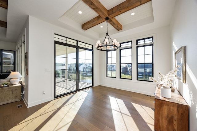 dining space featuring hardwood / wood-style floors, an inviting chandelier, and beam ceiling