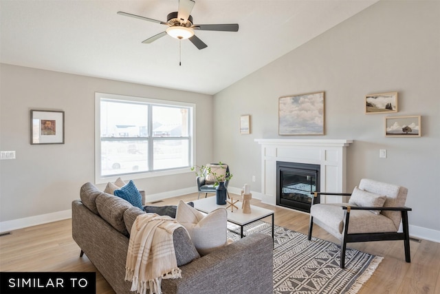 living room with lofted ceiling, ceiling fan, and light wood-type flooring