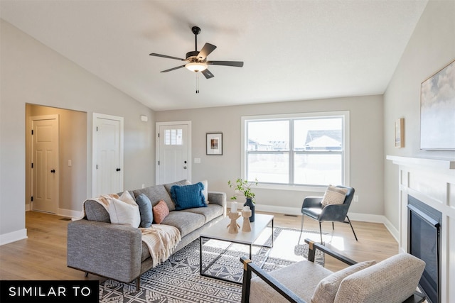 living room featuring ceiling fan, vaulted ceiling, and light hardwood / wood-style flooring