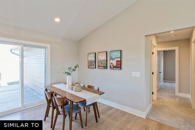 dining space with light carpet and lofted ceiling