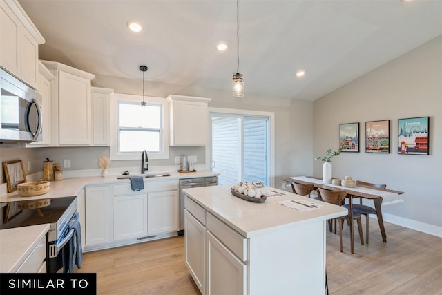 kitchen featuring sink, white cabinets, light hardwood / wood-style floors, hanging light fixtures, and lofted ceiling