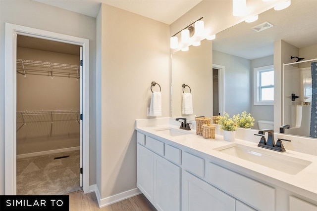 bathroom featuring vanity, toilet, wood-type flooring, and walk in shower