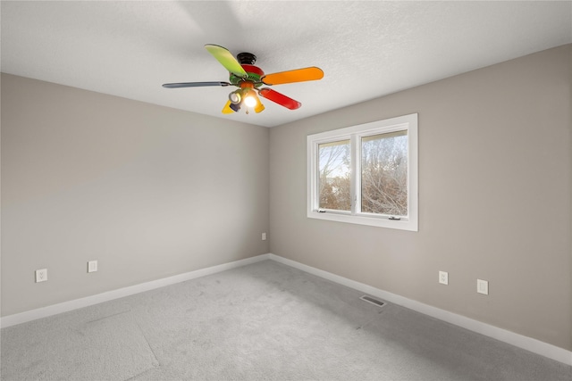 spare room with carpet, a textured ceiling, and ceiling fan