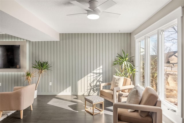 living area featuring ceiling fan and dark hardwood / wood-style flooring