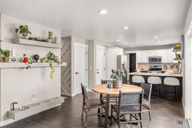 dining area with dark hardwood / wood-style flooring and a textured ceiling