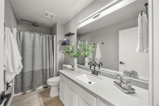 bathroom featuring hardwood / wood-style flooring, vanity, a textured ceiling, and toilet