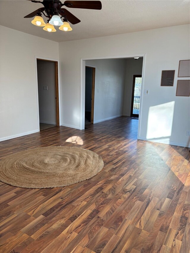 spare room with a textured ceiling, dark hardwood / wood-style flooring, and ceiling fan