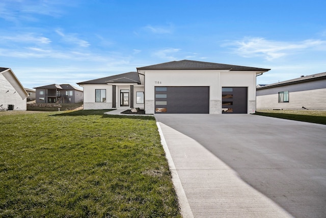 view of front of property with a garage, driveway, a front yard, stucco siding, and a shingled roof