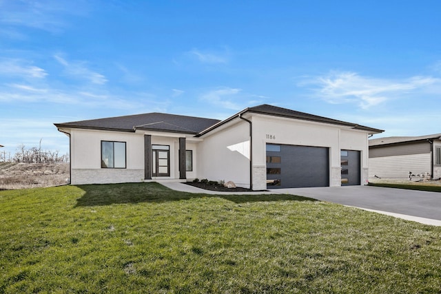 view of front of home featuring a garage, concrete driveway, a front yard, stucco siding, and stone siding