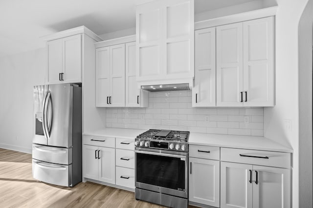 kitchen featuring appliances with stainless steel finishes, tasteful backsplash, white cabinetry, and light hardwood / wood-style floors