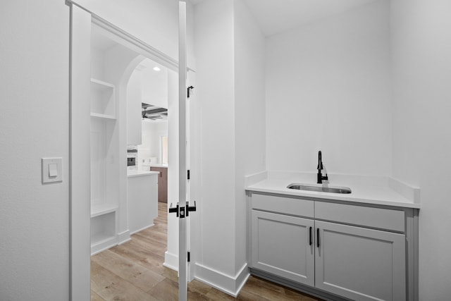 bathroom with wood finished floors, vanity, and baseboards