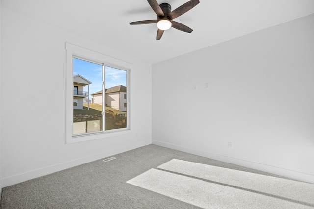 carpeted empty room featuring ceiling fan and baseboards
