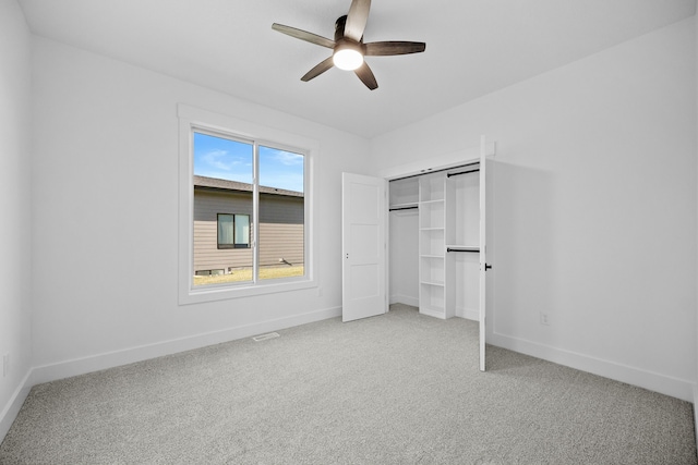 unfurnished bedroom with multiple windows, ceiling fan, a closet, and light carpet