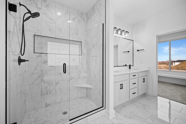 bathroom featuring a marble finish shower, double vanity, marble look tile flooring, and baseboards