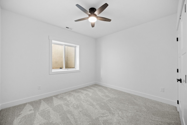 carpeted empty room with a ceiling fan and baseboards