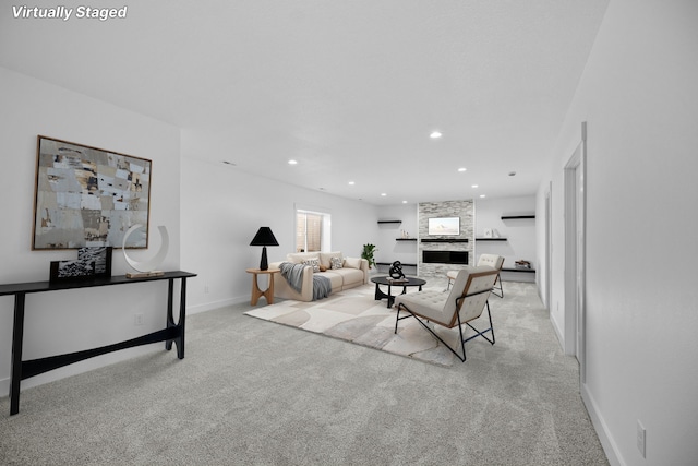 carpeted living area featuring baseboards, recessed lighting, and a fireplace