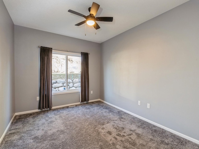 spare room with ceiling fan and carpet