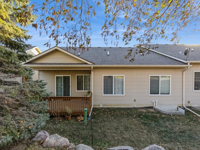 rear view of house with a wooden deck and a yard