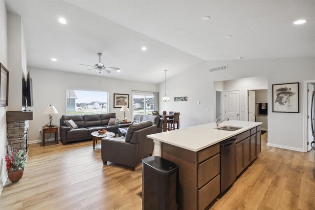 kitchen featuring light wood-type flooring, sink, a center island with sink, dishwasher, and lofted ceiling