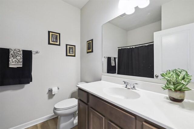 bathroom featuring hardwood / wood-style floors, vanity, and toilet