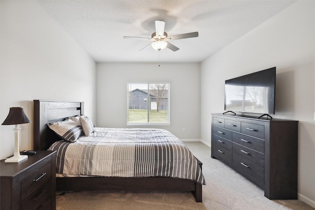 bedroom featuring ceiling fan, light colored carpet, and a textured ceiling