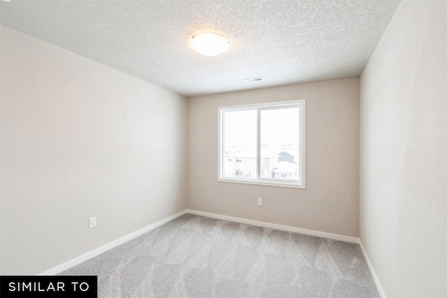 carpeted spare room with a textured ceiling