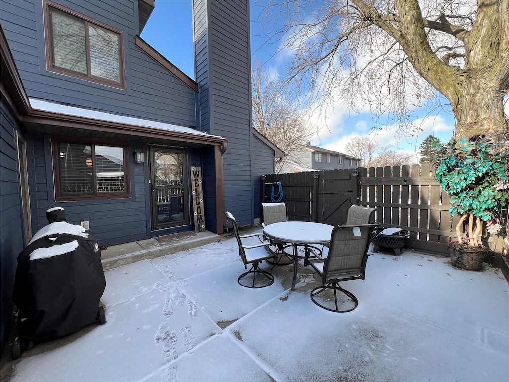 snow covered patio with a grill