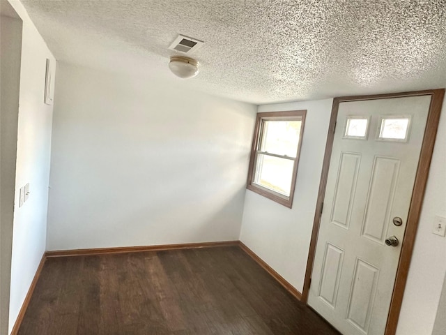 foyer with dark hardwood / wood-style flooring and a textured ceiling