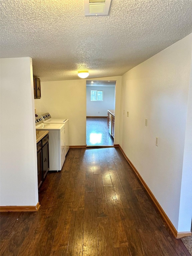 interior space featuring cabinets, a textured ceiling, dark hardwood / wood-style floors, and washer and dryer