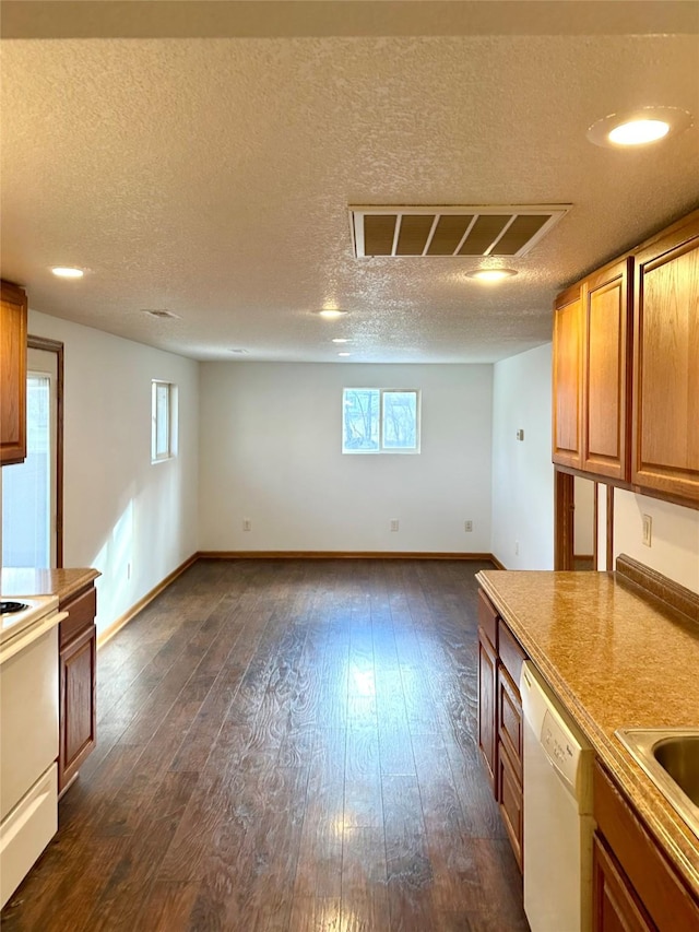 kitchen with a textured ceiling, sink, dark wood-type flooring, and white appliances