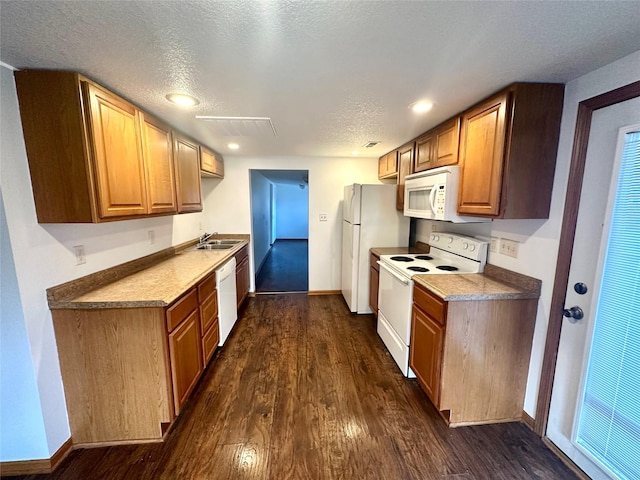 kitchen with dark hardwood / wood-style flooring, white appliances, a textured ceiling, and sink