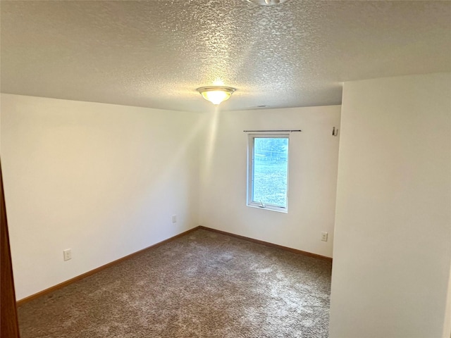 empty room with carpet flooring and a textured ceiling