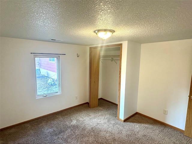 unfurnished bedroom with carpet, a textured ceiling, and a closet