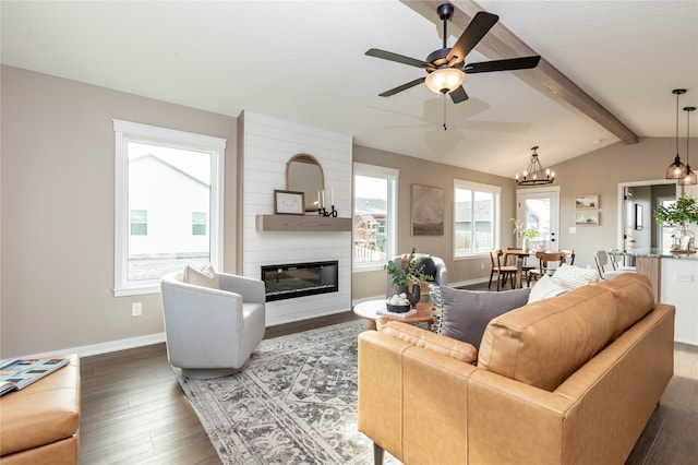 living room featuring lofted ceiling with beams, dark hardwood / wood-style flooring, a fireplace, and a wealth of natural light