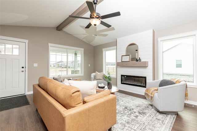 living room with a fireplace, hardwood / wood-style floors, vaulted ceiling with beams, and a wealth of natural light