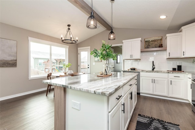 kitchen featuring white cabinetry, light stone countertops, a center island, and lofted ceiling with beams