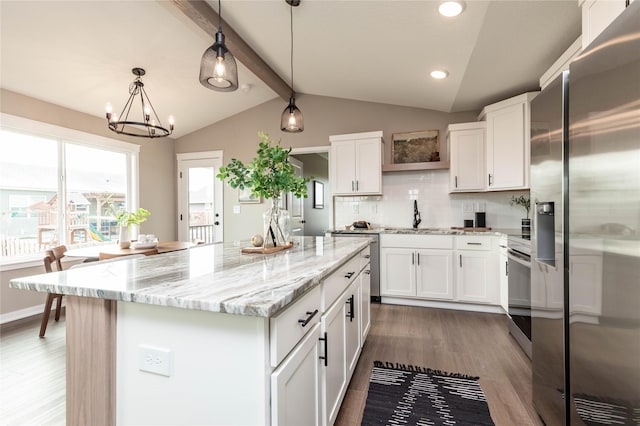 kitchen featuring appliances with stainless steel finishes, lofted ceiling with beams, white cabinetry, and hanging light fixtures