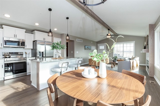 dining room with vaulted ceiling with beams, ceiling fan, and dark hardwood / wood-style flooring