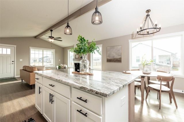 kitchen with plenty of natural light, white cabinets, decorative light fixtures, and hardwood / wood-style flooring