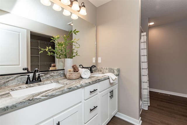 bathroom with vanity, a textured ceiling, and hardwood / wood-style flooring