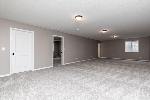 empty room with light carpet and a textured ceiling