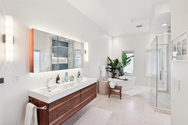 bathroom featuring tile patterned flooring, a freestanding tub, a sink, double vanity, and a stall shower