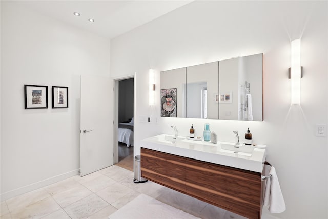 ensuite bathroom featuring recessed lighting, a sink, ensuite bath, and double vanity