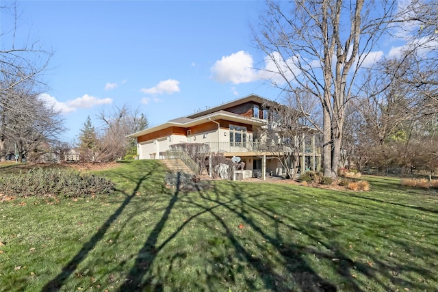 back of house with a yard, a wooden deck, and stucco siding