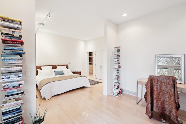 bedroom with light wood-type flooring, rail lighting, and recessed lighting