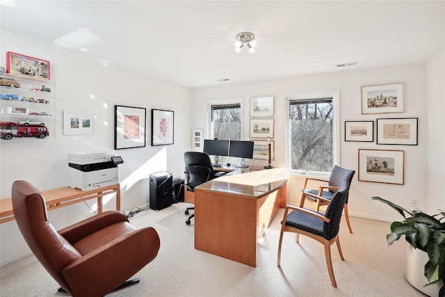 office space featuring light carpet, visible vents, and baseboards